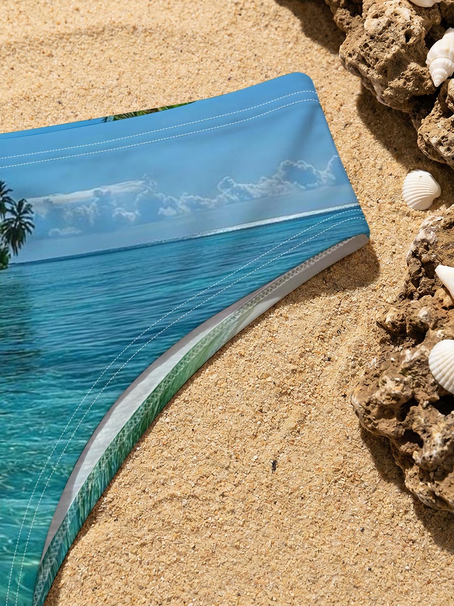 Crystal-clear turquoise waters meet a pristine white sand beach lined with lush palm trees under a bright blue sky. -  Men's swim trunks