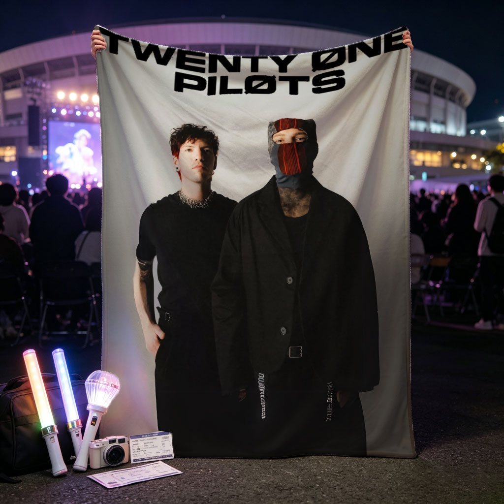 Twenty One Pilots Standing in Black Outfits with One Member Wearing a Mask and the Band Name Displayed Above Them - Blankets