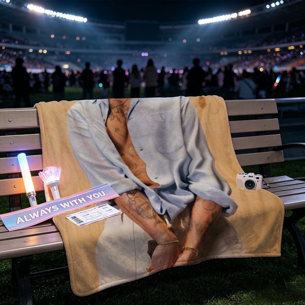 Bad Bunny in a Casual Pose Wearing an Open Light Blue Shirt and Beige Pants Against a Wooden Background - Blankets