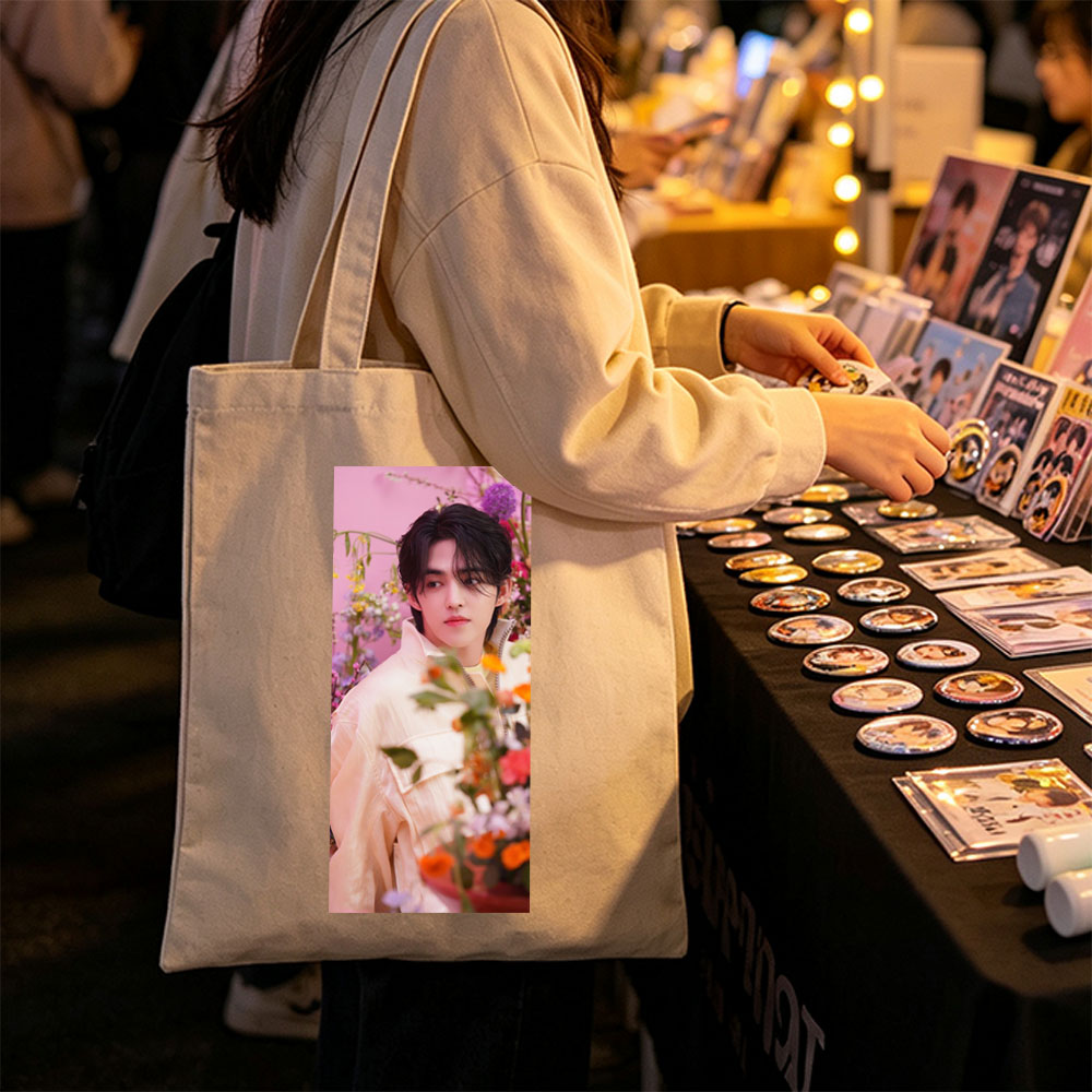 Sungchan in a floral garden, wearing a soft pink jacket with vibrant flowers in the foreground - Canvas tote bags