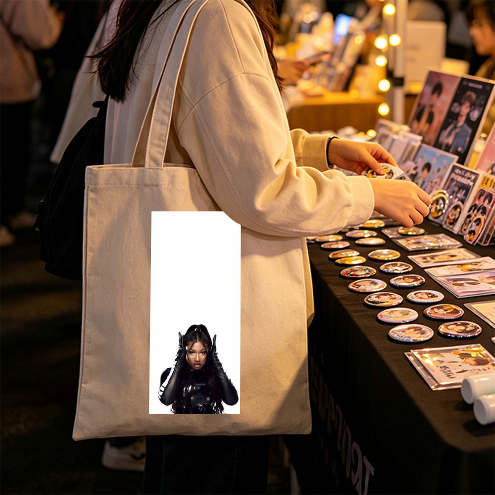 Megan Thee Stallion in a Bold Black Outfit with Hands on Head Against White Background - Canvas tote bags