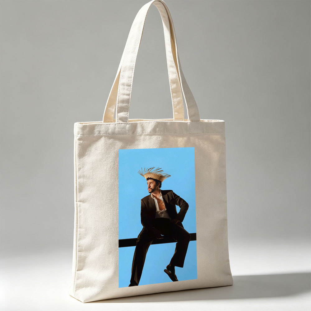 Bad Bunny in a Bold Fashion Statement Wearing a Straw Hat and Suit Against a Blue Background - Canvas tote bags
