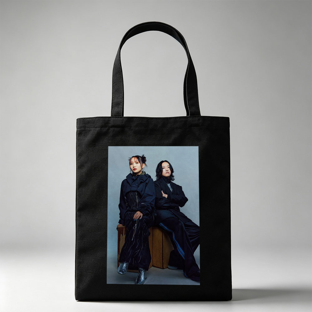 YOASOBI in a Stylish Studio Portrait Featuring Two Members Dressed in Dark, Edgy Fashion Sitting on Wooden Crates Against a Neutral Background - Canvas tote bags