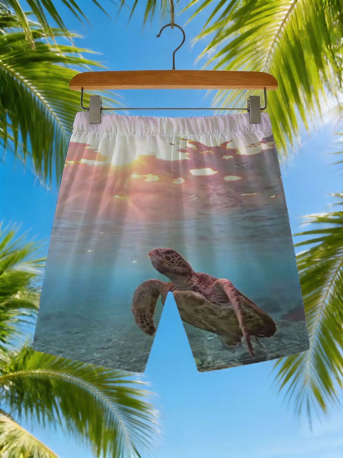Sea turtle swims gracefully underwater as sunlight filters through the ocean surface. -  Beach shorts