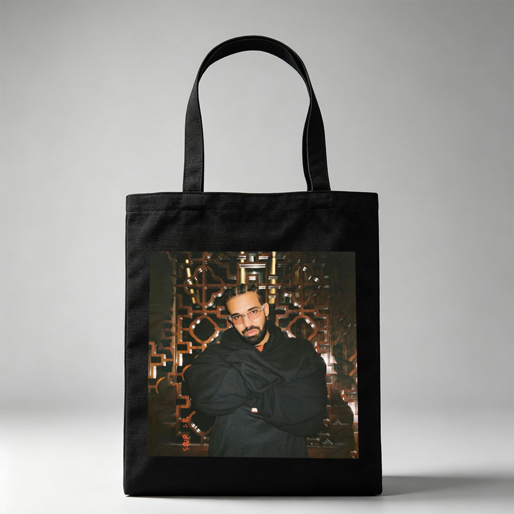 Drake in a Stylish Pose Against an Ornate Background Wearing Glasses and a Black Hoodie - Canvas tote bags