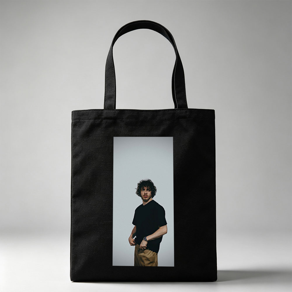 Jack Whitehall in a Casual Pose Wearing a Black T-Shirt and Beige Pants Against a Neutral Background - Canvas tote bags