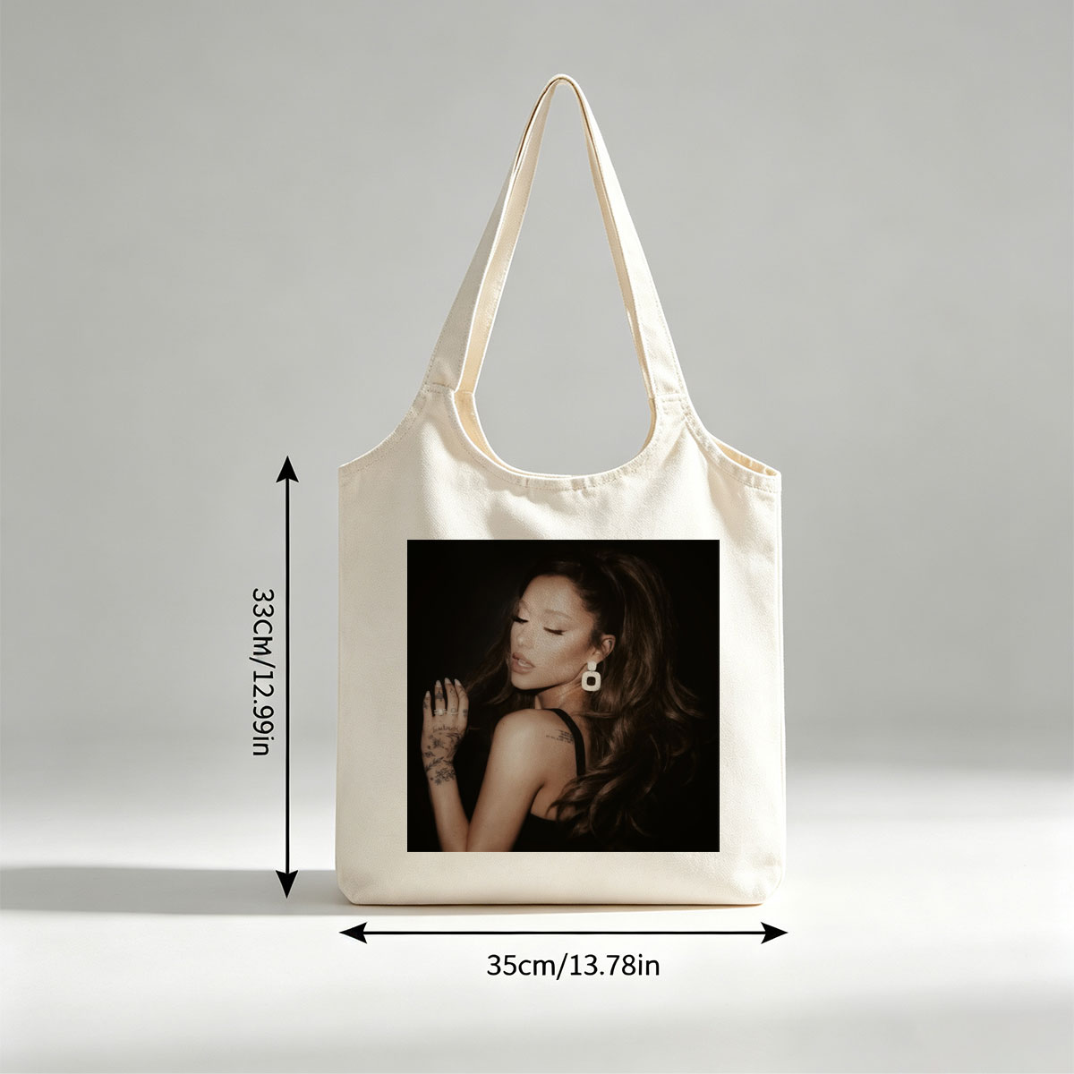 Ariana Grande in a Dramatic Pose with Long Hair and Tattoos on Dark Background - Canvas shoulder bags/
