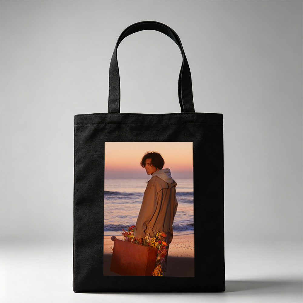 Takuya Kimura on Beach at Sunset Holding Flower-Adorned Suitcase - Canvas tote bags