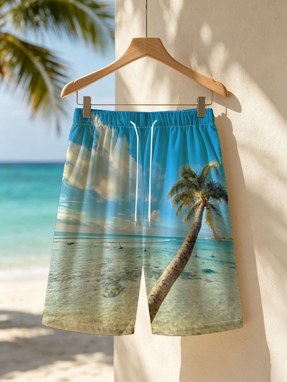 Tropical beach with palm tree leaning over clear blue water under a bright sky. -  Beach shorts