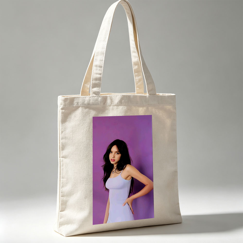 Olivia Rodrigo in a Light Blue Dress Posing Against Purple Background - Canvas tote bags
