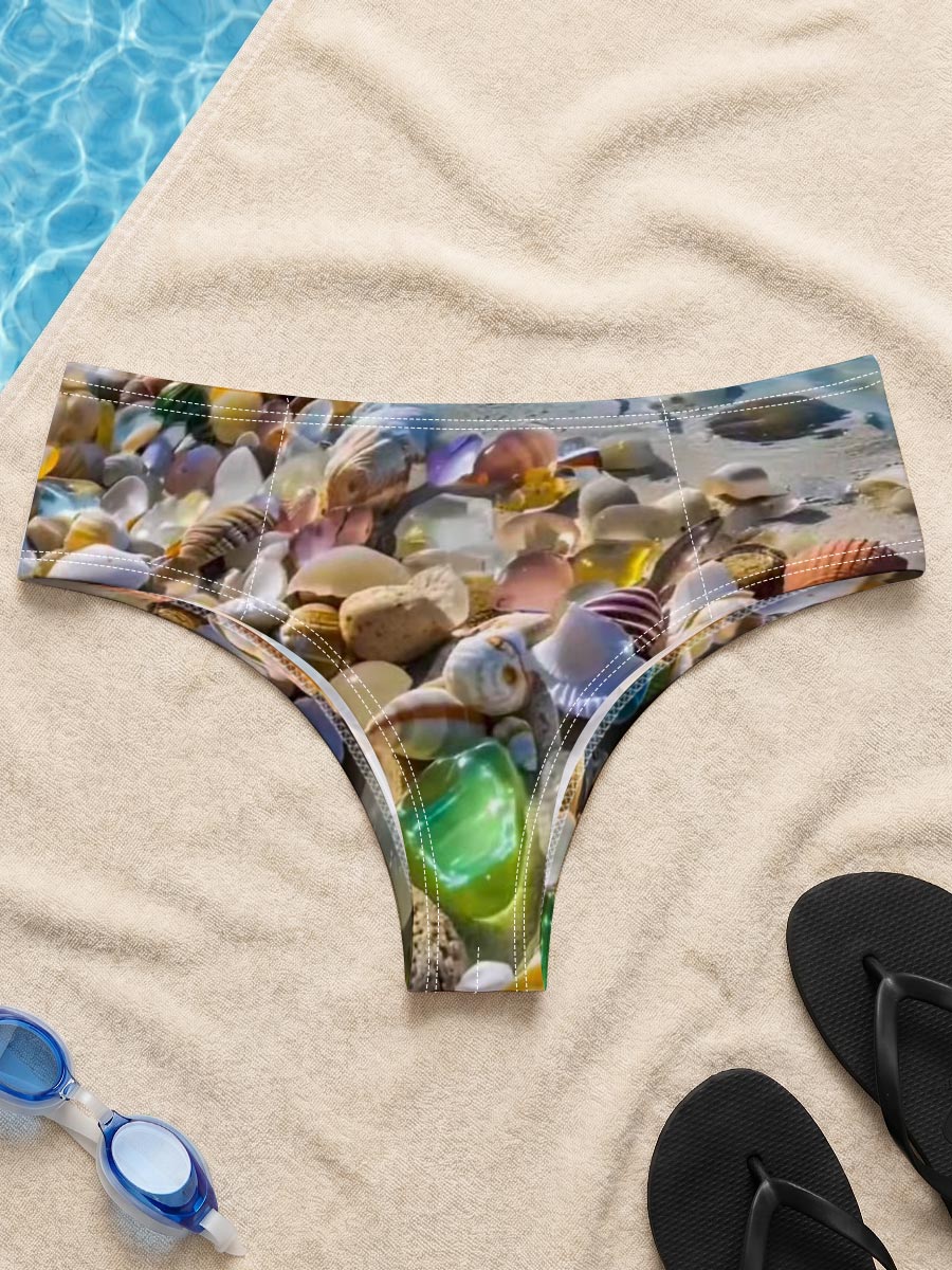 Colorful seashells on a tropical beach with clear blue water and sky. -  Men's swim trunks