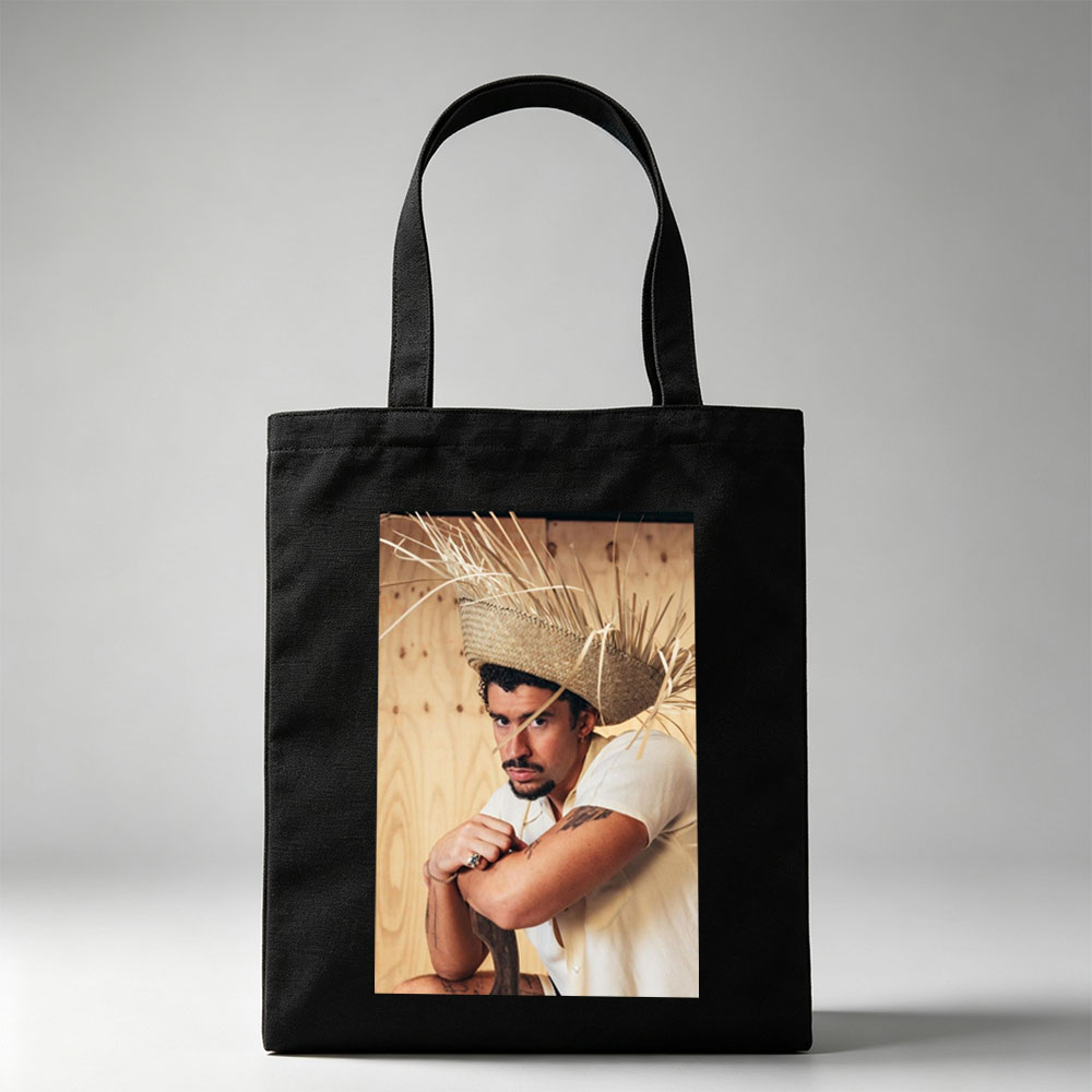 Bad Bunny Wearing a Straw Hat with Hay Sticks, Leaning Against a Wooden Wall in a Casual Pose - Canvas tote bags