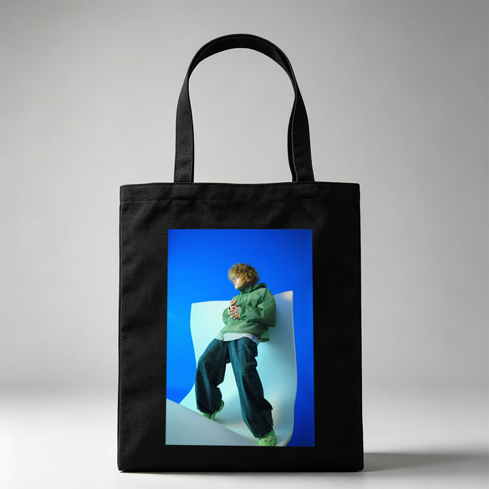 Jaden Smith in a Fashion Shoot Wearing Oversized Green Jacket and Baggy Jeans Against a Blue Background - Canvas tote bags