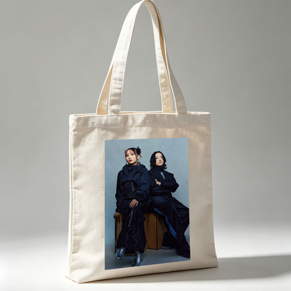 YOASOBI in a Stylish Studio Portrait Featuring Two Members Dressed in Dark, Edgy Fashion Sitting on Wooden Crates Against a Neutral Background - Canvas tote bags