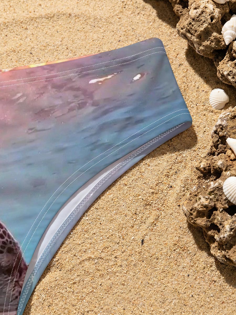 Sea turtle swims gracefully underwater as sunlight filters through the ocean surface. -  Men's swim trunks