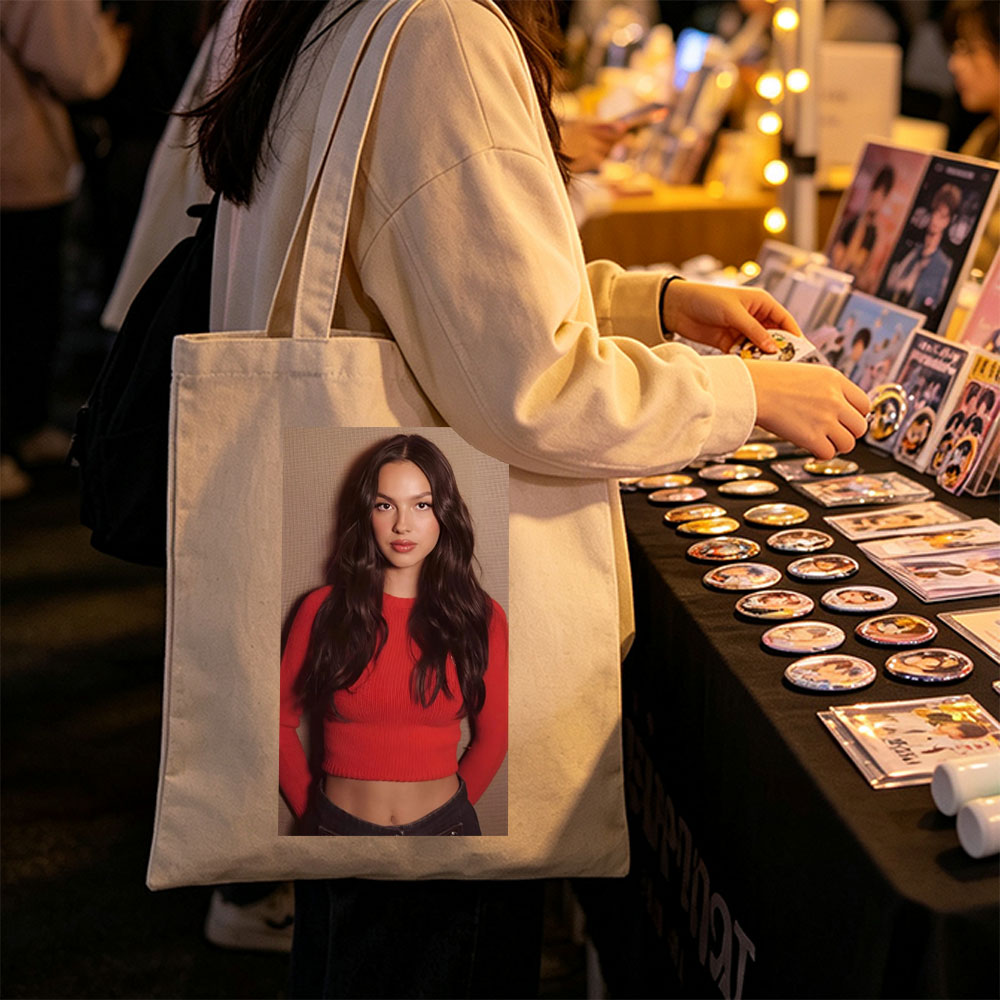 Olivia Rodrigo in a Bold Red Crop Top and Jeans, Striking a Confident Pose Against a Textured Background - Canvas tote bags